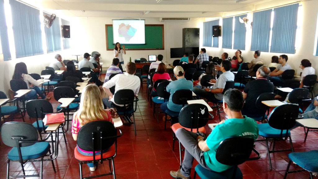 Sala de aula com pessoas assistindo a uma palestra.